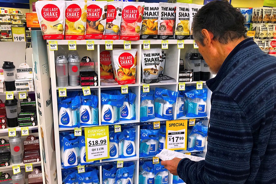 A customer looks at products marked with discounted prices on display at a chemist in a shopping mall in central Sydney, Australia on July 25, 2018 — Reuters/Files