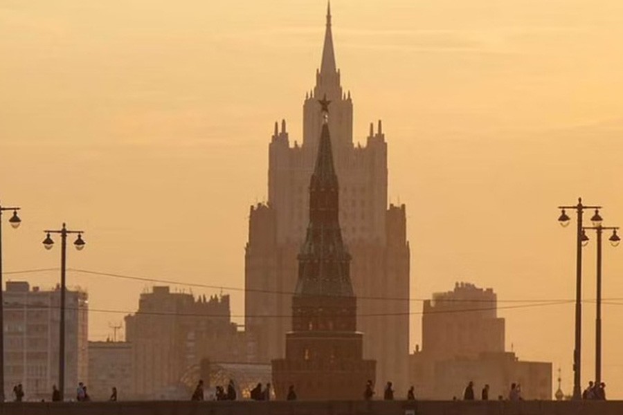 People walk at a bridge over Moskva river with a Foreign Ministry building in the background in central Moscow, Russia Sept 11, 2017.REUTERS