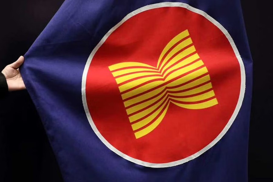 A worker adjusts an ASEAN flag at a meeting hall in Kuala Lumpur, Malaysia, Oct 28, 2021. REUTERS