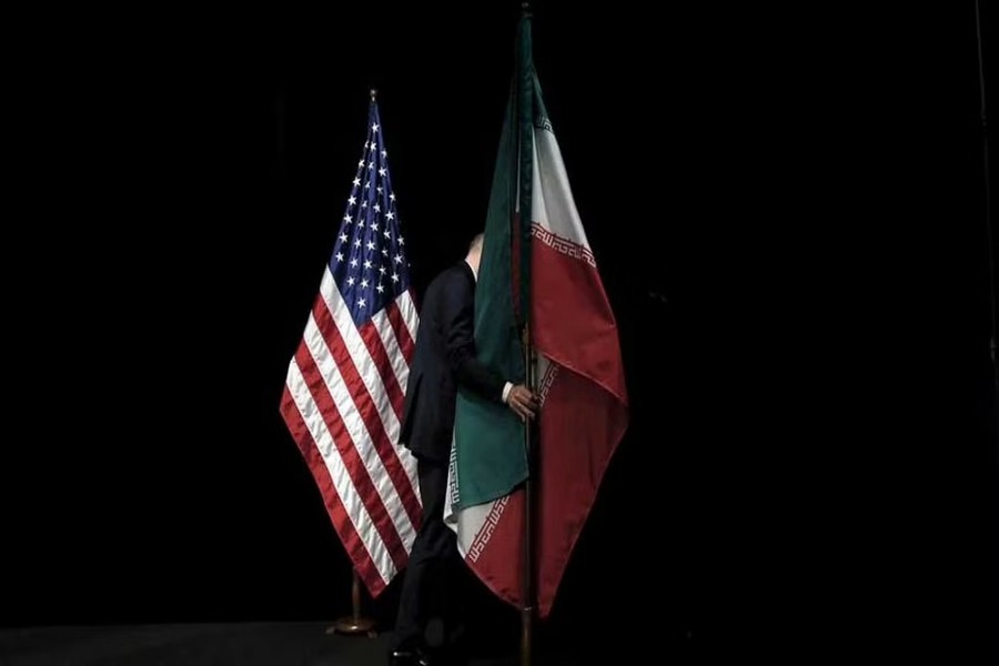 A staff member removes the Iranian flag from the stage after a group picture with foreign ministers and representatives of United States, Iran, China, Russia, Britain, Germany, France and the European Union during the Iran nuclear talks at the Vienna International Center in Vienna, Austria, July 14, 2015. REUTERS/Carlos Barria/Files