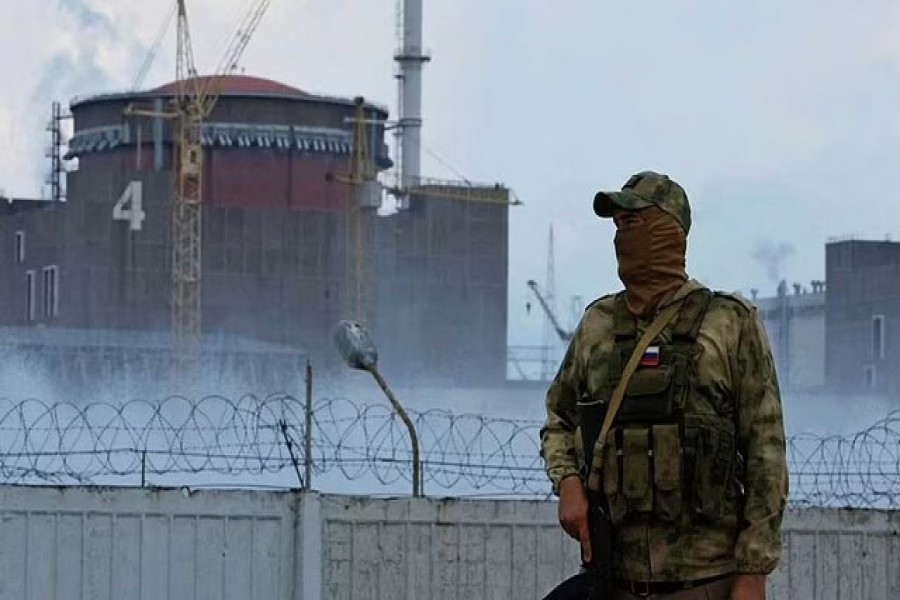 A serviceman with a Russian flag on his uniform stands guard near the Zaporizhzhia Nuclear Power Plant in the course of Ukraine-Russia conflict outside the Russian-controlled city of Enerhodar in the Zaporizhzhia region, Ukraine August 4, 2022. REUTERS/Alexander Ermochenko