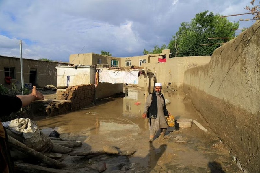 An Afghan man cleans up his damaged home after the heavy flood in the Khushi district of Logar, Afghanistan, August 21, 2022. Reuters