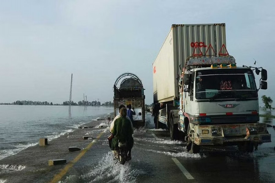 Vehicles move along a flooded road, following rains and floods during the monsoon season in Mehar, Pakistan August 29, 2022. REUTERS/Akhtar Soomro