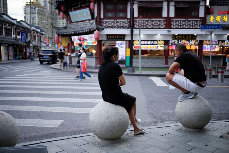 People rest on stone barricades on a street, following the coronavirus disease (COVID-19) outbreak, in Shanghai, China, September 9, 2022. REUTERS/Aly Song