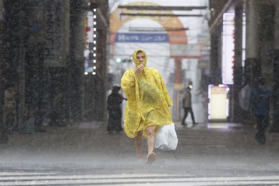 A man walks on the street in heavy rain and wind caused by Typhoon Nanmadol in Kagoshima on Japan's southernmost main island of Kyushu September 18, 2022, in this photo taken by Kyodo. Kyodo via REUTERS