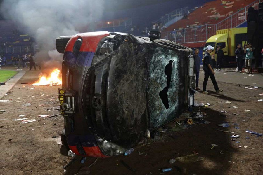 A damaged car is pictured following a riot after the league BRI Liga 1 football match between Arema vs Persebaya at Kanjuruhan Stadium, Malang, East Java province, Indonesia, October 2, 2022, in this photo taken by Antara Foto. Antara Foto/H Prabowo/via REUTERS ATTENTION EDITORS - THIS IMAGE HAS BEEN SUPPLIED BY A THIRD PARTY. MANDATORY CREDIT. INDONESIA OUT. NO COMMERCIAL OR EDITORIAL SALES IN INDONESIA.