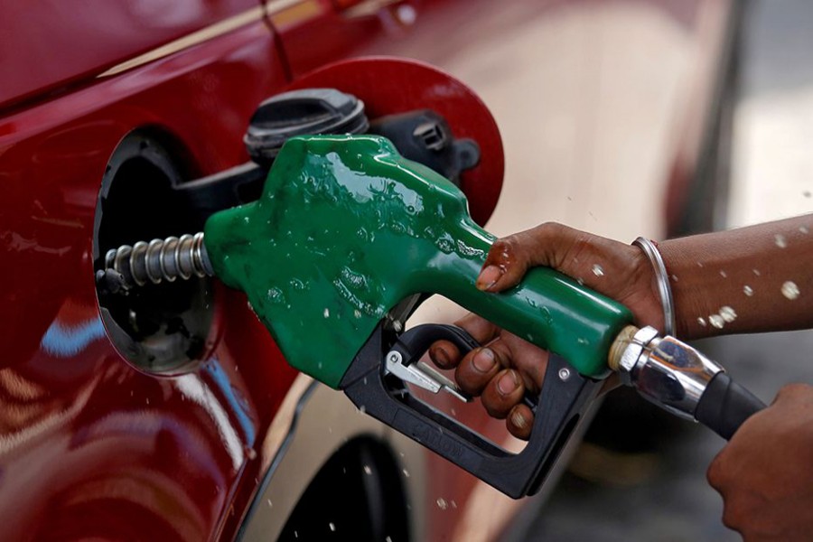 A worker holds a nozzle to pump petrol into a vehicle at a fuel station in Mumbai, India on May 21, 2018 — Reuters/Files