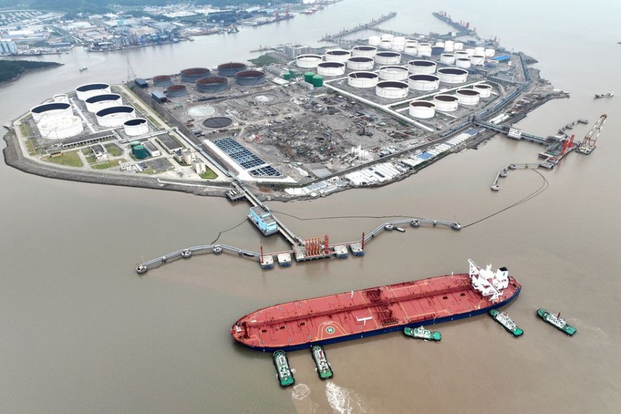 An aerial view shows tugboats helping a crude oil tanker to berth at an oil terminal, off Waidiao Island in Zhoushan, Zhejiang province, China July 18, 2022. cnsphoto via REUTERS