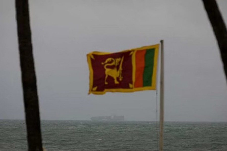 A cargo ship sails towards Colombo Harbour as a Sri Lankan national flag is seen, amid the country's economic crisis in Colombo, Sri Lanka, July 23, 2022. REUTERS/Adnan Abidi