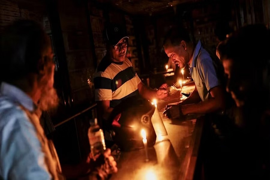  A pharmaceutical shop uses candle lights to serve customers during countrywide blackout in Dhaka, Bangladesh, October 4, 2022.REUTERS/Mohammad Ponir Hossain