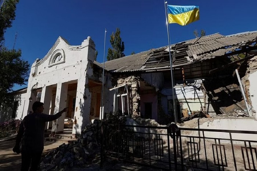 A Ukrainian national flag rises over a local council's headquarter building, heavily damaged during Russia's attack in the village of Lymany near a frontline in Mykolaiv region, Ukraine Oct 18, 2022. REUTERS