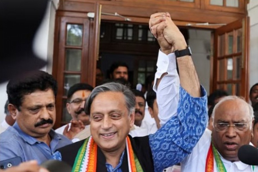 Mallikarjun Kharge, newly elected president of the Congress party, India's main opposition party, raises his hand with party colleague Shashi Tharoor at Kharge’s residence in New Delhi, India, Oct 19, 2022.REUTERS