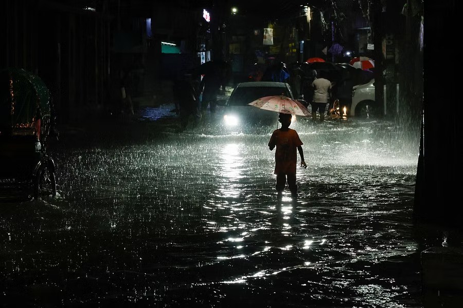 A boy wades through water as streets are flooded due to continuous rain, before Cyclone Sitrang hits the country in Dhaka, Bangladesh, Oct 24, 2022. REUTERS/Mohammad Ponir Hossain