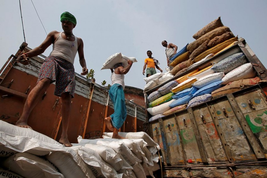 A labourer carries a sack filled with sugar to load it onto a supply truck at a wholesale market in Kolkata, India on November 14, 2018 — Reuters/Files