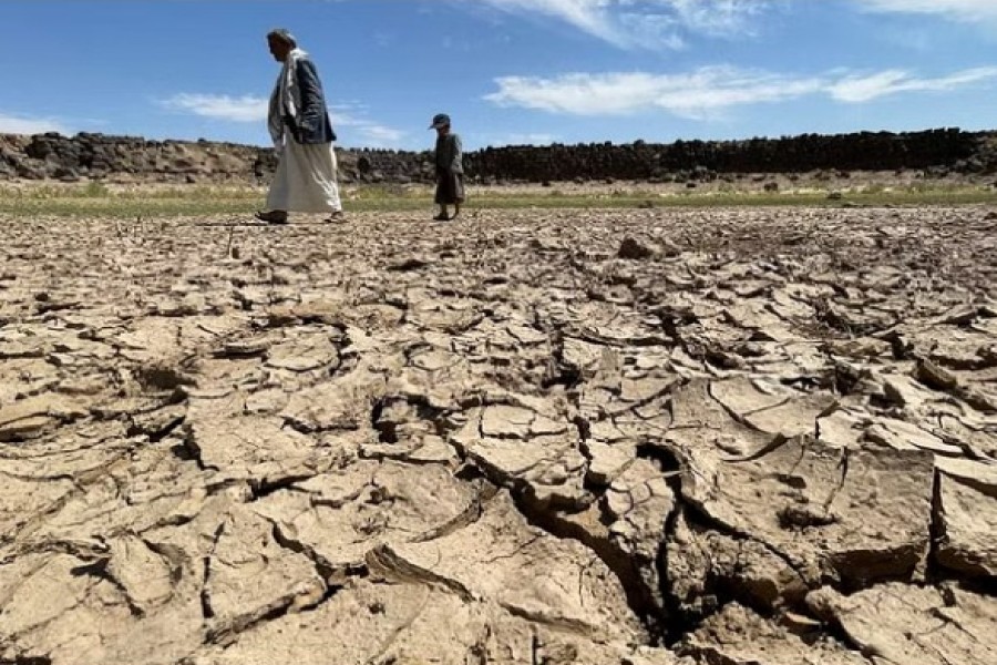 People walk on the cracked soil caused by drought on the outskirts of Sanaa, Yemen, Oct 20, 2022. REUTERS