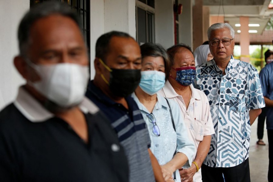 Malaysian Caretaker Prime Minister Ismail Sabri Yaakob stands in a line to vote during Malaysia's 15th general election in Bera, Pahang, Malaysia on November 19, 2022 — Reuters photo