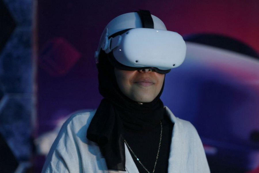 A Palestinian girl Nisreen Shamalakh wears virtual reality glasses inside a gaming store in Gaza City, November 22, 2022. REUTERS/Ibraheem Abu Mustafa