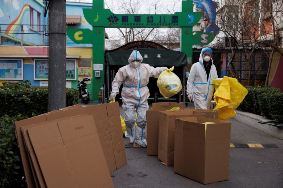 Epidemic prevention workers in protective suits put medical waste into boxes in a residential compound as outbreaks of the coronavirus disease (Covid-19) continue in Beijing, China on November 27, 2022 — Reuters photo