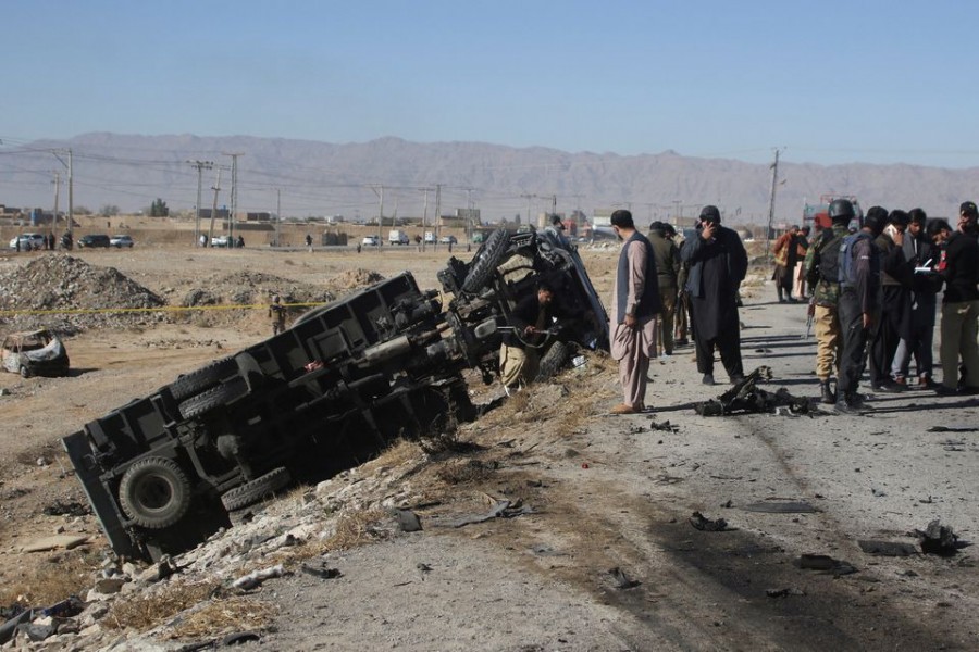 Police officers in civilian clothes survey the aftermath of a suicide bomb blast on a police patrol in Quetta, Pakistan, November 30, 2022. REUTERS/Naseer Ahmed