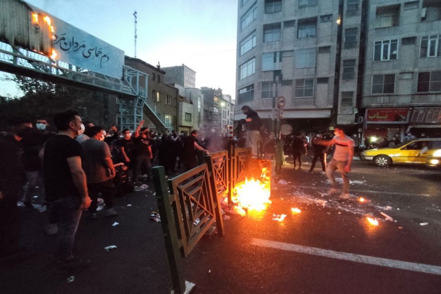 People light a fire during a protest over the death of Mahsa Amini, a woman who died after being arrested by the Islamic republic's "morality police", in Tehran, Iran September 21, 2022. WANA (West Asia News Agency) via REUTERS