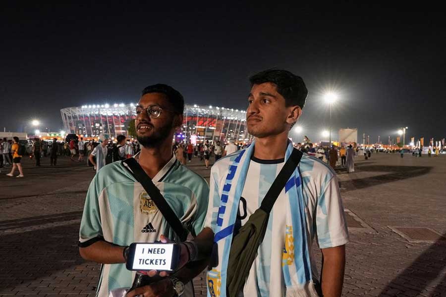 A man holding a smartphone with a sign that reads: "I need tickets" ahead of a FIFA World Cup Qatar 2022 match in Qatar on last November 30 –Reuters file photo