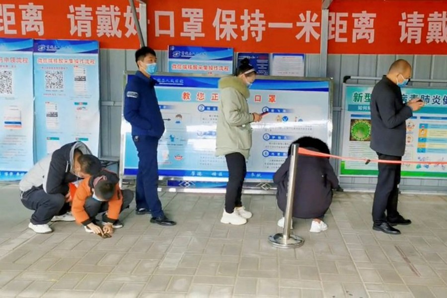 People wait in line at a coronavirus disease (Covid-19) test centre in Xinyang, China, this still image obtained from social media video released on December 15, 2022 — Via Reuters