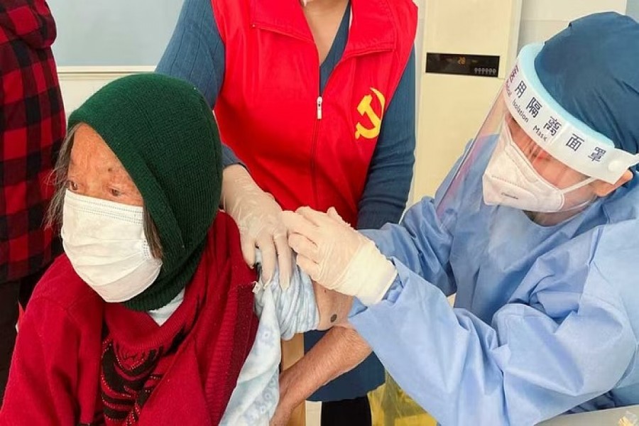 A medical worker administers a dose of a vaccine against COVID-19 to an elderly resident, during a government-organized visit to a vaccination center in Zhongmin village on the outskirts of Shanghai, China December 21, 2022. Reuters