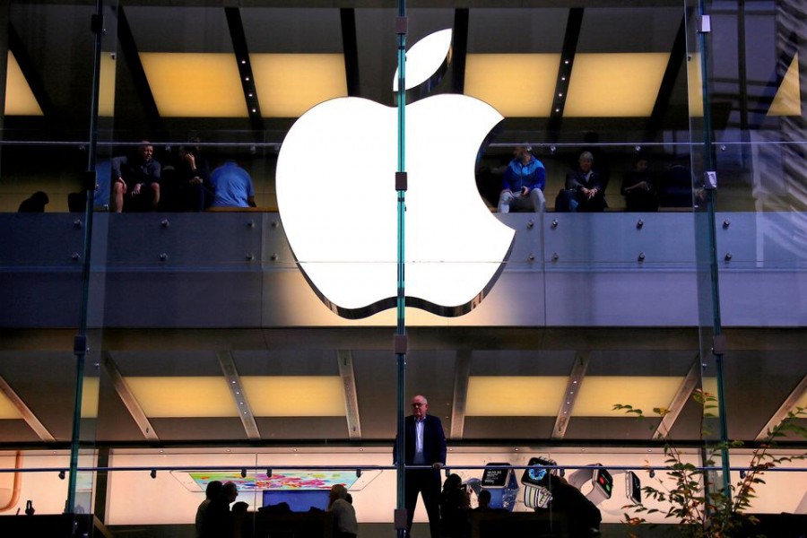 A customer stands underneath an illuminated Apple logo as he looks out the window of the Apple store located in central Sydney, Australia on May 28, 2018 — Reuters/Files