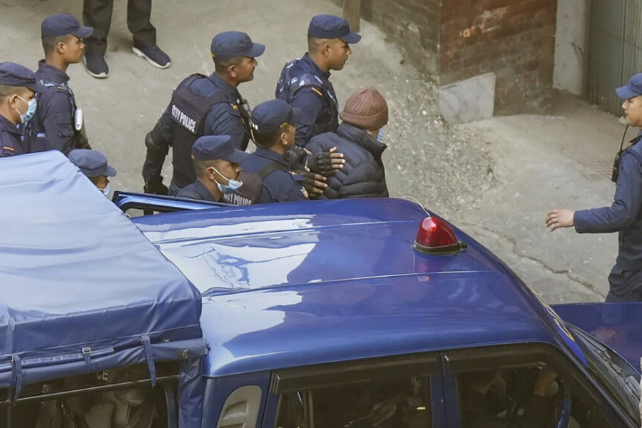 Nepalese police escort Charles Sobhraj, in brown cap, to the immigration office, in Kathmandu, Nepal, Friday, Dec. 23, 2022. Confessed French serial killer Charles Sobhraj has been released from prison in Nepal after serving most of his sentence. Sobhraj was driven out of Central Jail in Kathmandu to the Department of Immigration under heavy guard Friday after the Supreme Court ordered him to be released because of poor health and good behavior. (AP Photo/Niranjan Shrestha)