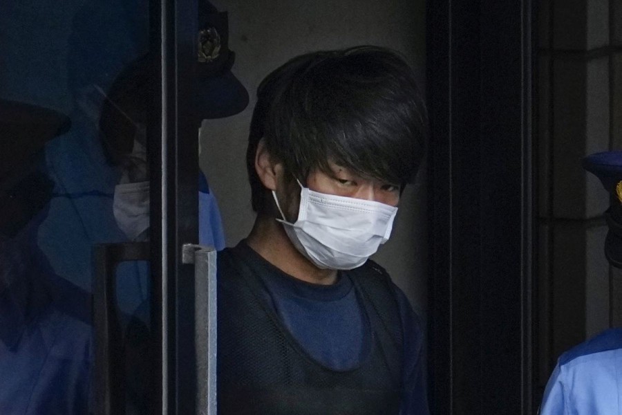 Tetsuya Yamagami, Suspected of killing former Japanese premier Shinzo Abe, is escorted by a police officer as he is taken to prosecutors, at Nara-nishi police station in Nara, western Japan, in this photo taken by Kyodo July 10, 2022. Mandatory credit Kyodo via REUTERS