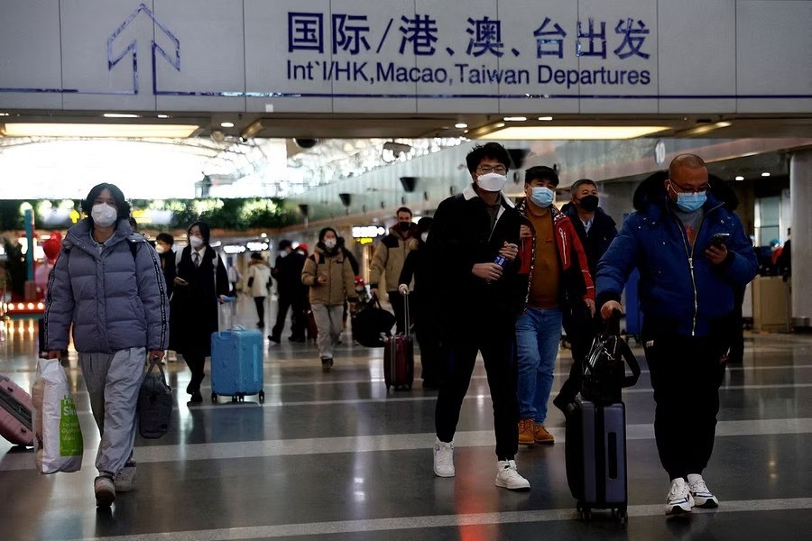 Travellers walk with their luggage at Beijing Capital International Airport, amid the coronavirus disease (COVID-19) outbreak in Beijing, China December 27, 2022. REUTERS