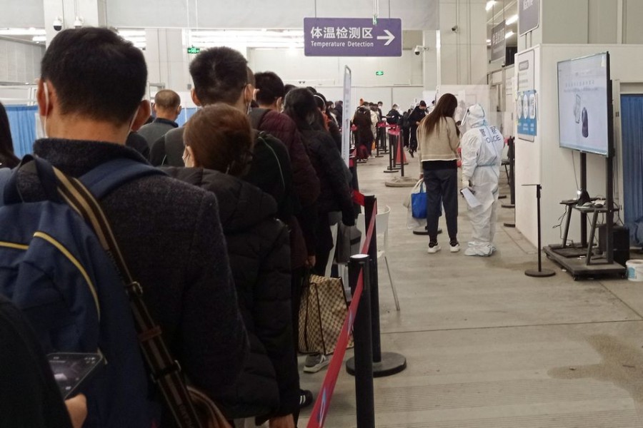 Passengers arriving on international flights wait in line next to a police officer wearing personal protective equipment (PPE) and speaking with a woman at the airport in Chengdu, China January 6, 2023. REUTERS/Staff