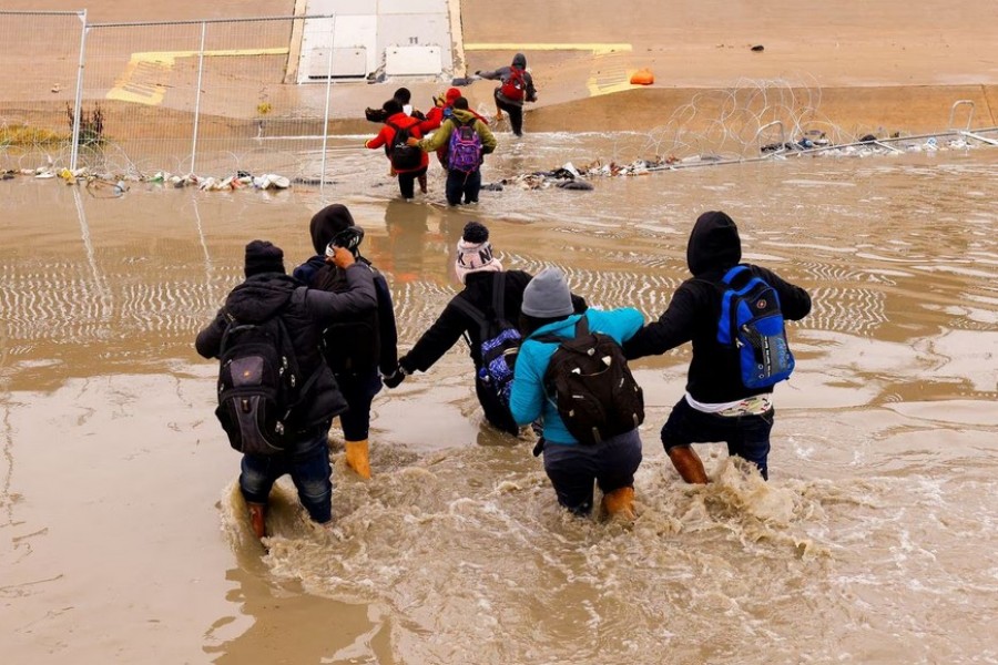 Asylum-seeking migrants cross the Rio Bravo river, the border between the United States and Mexico, to request asylum in El Paso, Texas, U.S., as seen from Ciudad Juarez, Mexico January 2, 2023. REUTERS/Jose Luis Gonzalez/File Photo