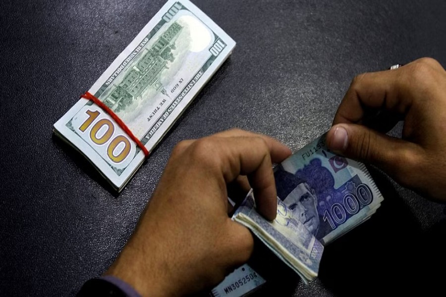 A currency trader counts Pakistani Rupee notes as he prepares an exchange of US dollars in Islamabad, Pakistan Dec 11, 2017. REUTERS