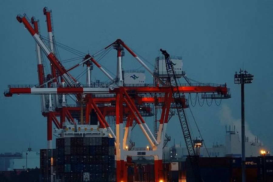 A cargo ship and containers are seen at an industrial port in Tokyo, Japan, Feb 15, 2022. REUTERS