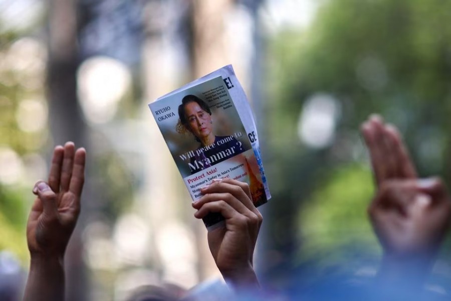 A protester holds up a picture of Aung San Suu Kyi while others hold up three-finger salutes, during a demonstration to mark the second anniversary of Myanmar's 2021 military coup, outside the Embassy of Myanmar in Bangkok, Thailand on February 1, 2023 — Reuters photo