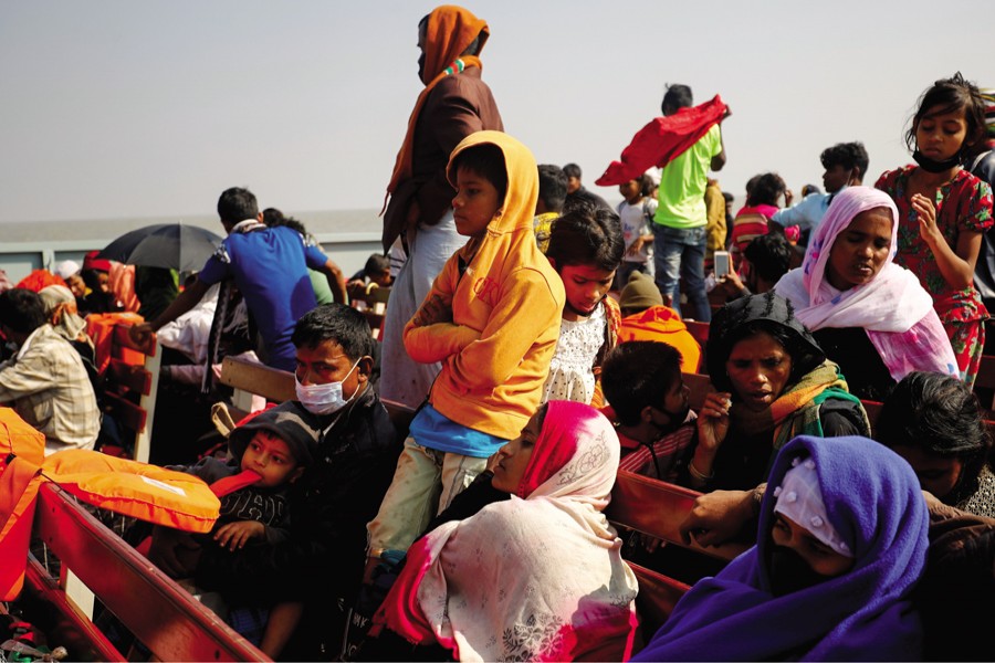 Rohingya refugees sit on wooden benches of a navy vessel on their way to the Bhasan Char island in Noakhali district, Bangladesh, December 29, 2020. 	—Reuters Photo