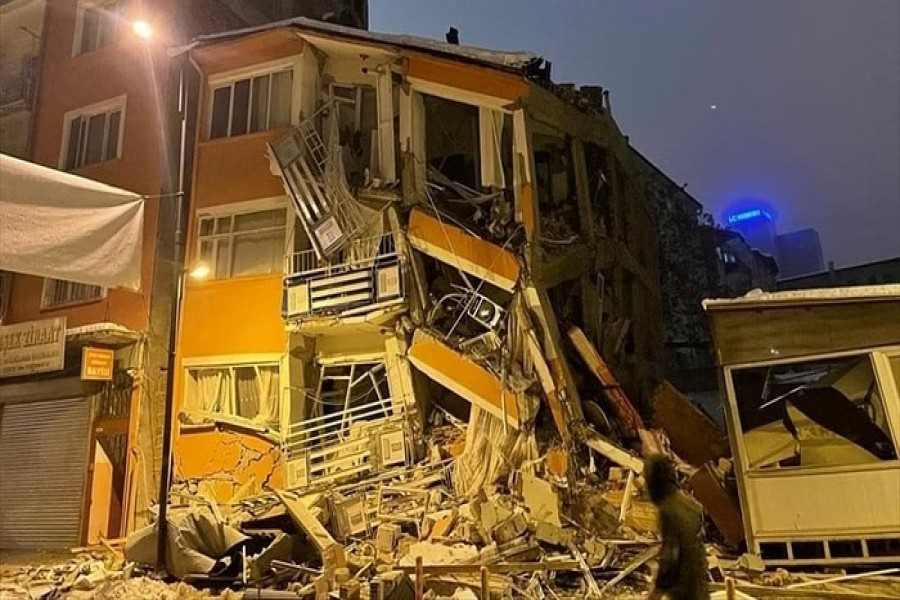 A man walks past by a collapsed building after an earthquake in Malatya, Turkey Feb 6, 2023. Depo Photos via REUTERS