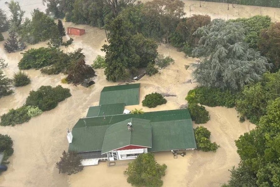 An NH90 helicopter and crew recover people from the rooftops of their homes in Esk Valley, Napier in this handout photo released on February 14, 2023 — New Zealand Defence Force/Handout via REUTERS