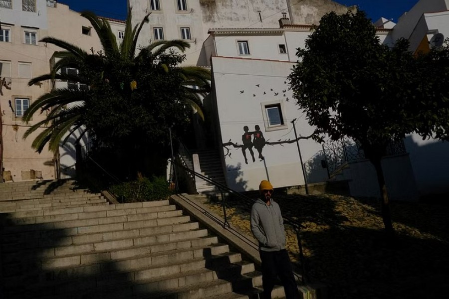 A person walks in Alfama neighbourhood in Lisbon, Portugal, February 16, 2023. REUTERS